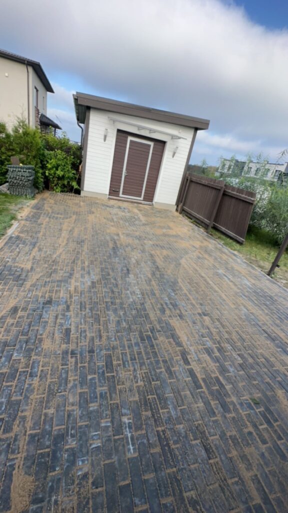 Suur hall tänavakivi sissesõidutee paigaldus Raplamaal - betoonkivi laomine käib